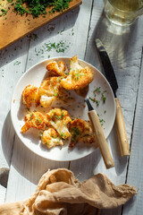 Cauliflower fried breaded with dill on a white plate