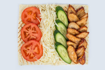 Shawarma filling on a white plate under cutting