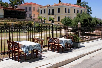 Fototapeta na wymiar Greece, Athens, June 28 2020 - Empty chairs and tables of a traditional restaurant in the touristic district of Plaka. 