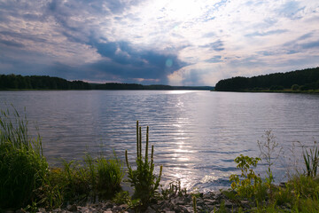 Some minutes before a thunderstorm. sun rays over the river. Belarusian nature. Forest Lake.