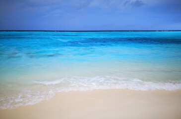 Tropical Maldives beach with white sand and blue sky.