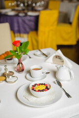 Milk porridge with fruits. Breakfast in empty restaurant. Social distancing