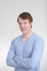 Portrait of happy young handsome man smiling with arms crossed