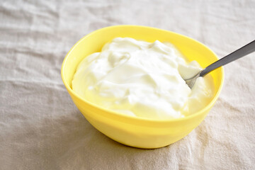 Greek yogurt on a yellow bowl.  Selective focus.