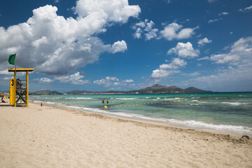 Mallorca sea beach view after storm. Sea water of different colours. White clouds, blue sky, sunny summer day. Holidays in Spain.