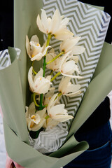 Bouquet of orchid flowers in pistachio-colored package