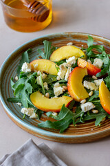 Salad with peach, arugula, cheese, nuts and honey. Healthy eating. Vegetarian food. Recipe.