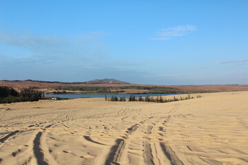 Footprints are stepping on brown sand , small step to future step has background is blue sky in fresh day. hope in life concept. 