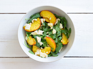 Salad with peach, arugula, cheese, nuts and honey. Healthy eating. Vegetarian food. Recipe.