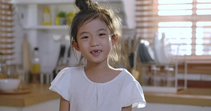 Close up portrait of Young asian little girl smiling with a toothless smile. Show no teeth.