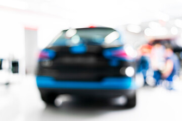 Blurred abstract image of man worker with car in body shop. Blur car auto service. Car bokeh. Blurred background with car in garage. Vehicle maintenance in auto repair service. Blurry service station