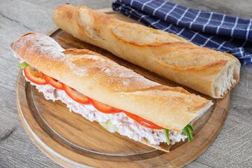 sandwich au thon et crudités sur une planche à découper