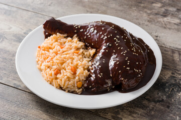 Traditional mole Poblano with rice in plate on wooden table