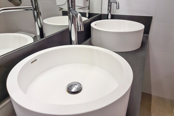 Modern white bathroom sink with faucet. Bathroom interior sink with modern design in luxury hotel.