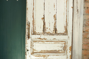 Old, white painted doors, closed, indoors with red brick wall and green wall