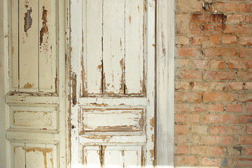 Old, white painted doors, closed, indoors with red brick walls