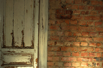 Old, white painted doors, closed, indoors with red brick walls, illuminated by the rays of the sun from the window