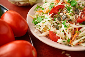 healthy food - fresh chopped vegetables on a wooden background, tomatoes and greens