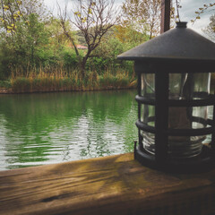 wooden bridge over lake and a lantern