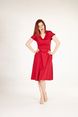 Smiling redhead girl on white background red dress