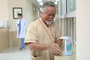 Happy senior patient cleaning hand  at hospital