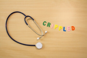 stethoscope on the table with the letters of the alphabet moving to form the word cripple