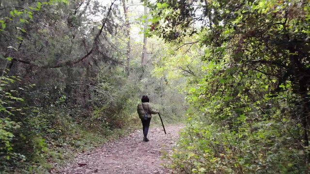 Persona atrav&eacute;sando un camino en el bosque