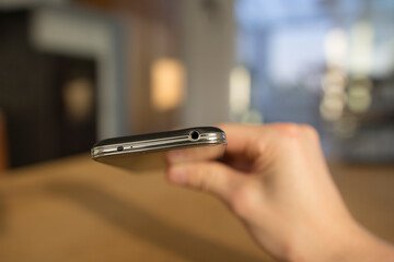 A detail of the 3.5mm jack and the infrared sender on the botom or top of a mobile phone. A male...