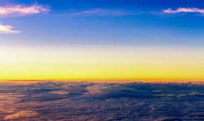Fototapeta na wymiar Top view of fluffy clouds on sunset sky view from flying airplane