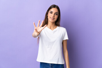 Young caucasian woman isolated on blue background happy and counting four with fingers