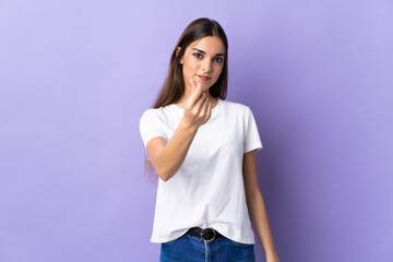 Young caucasian woman isolated on blue background making money gesture
