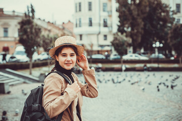 Cute brunette girl in funny hat on the way to university on her first day abroad.