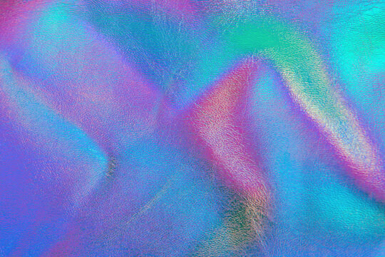 Retro holographic metallic leather background. Abstract colorful vibrant iridescent gradient. Retro futuristic design. Real texture violet, pink, mint and blue colors with scratches and irregularities