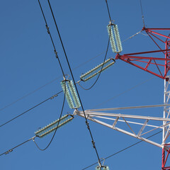 High voltage electricity pylon and power lines with clear blue sky