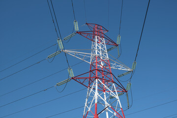 High voltage electricity pylon and power lines with clear blue sky