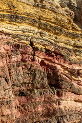 Cliff face showing multi-colored sediments in the Costa Vicentina natural park at the Atlantic Ocean at the Algarve, Portugal.