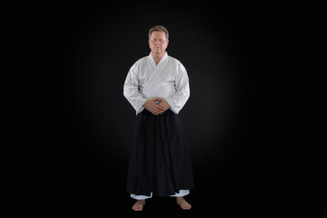 Portrait aikido master wearing traditional samurai hakama clothes. on black Background