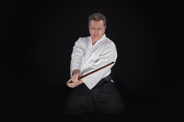 Portrait aikido master wearing traditional samurai hakama kimono. learning fight with bamboo boken