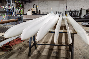 Two sets of freshly made blades for wind turbines in a factory floor. The picture was taken in Russia, in the Orenburg region, in the production room of an industrial enterprise