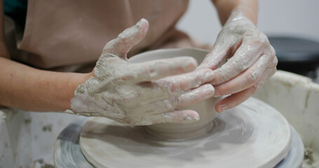 Potter making ceramic pot on the pottery wheel