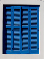 Lovely blue wooden shutters in greece, rustic and romantic background.