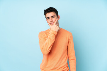 Obraz premium Teenager caucasian handsome man isolated on purple background thinking an idea