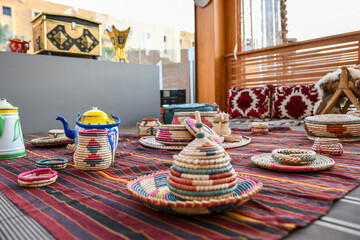 Traditional Arabic food sitting board or bench, tea pot and some hand made straw or wicker tools....