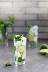 Mojito cocktail with lime and mint in glass. Mojito cocktail on dark stone table, selective focus.