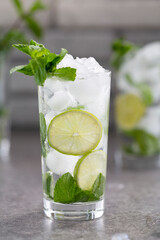 Mojito cocktail with lime and mint in glass. Mojito cocktail on dark stone table, selective focus.