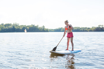 Fototapeta na wymiar A beautiful woman practicing paddle on a beautiful sunny day