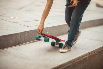 Asian woman skateboarder using smartphone in modern city