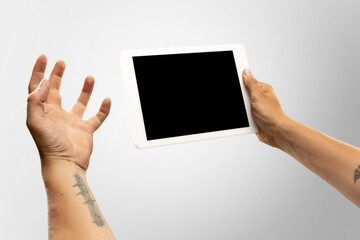 Angry, upset, exciting. Close up male hands holding tablet with blank screen during online watching of popular sport matches, championships. Copyspace for ad. Devices, gadgets, technologies concept.