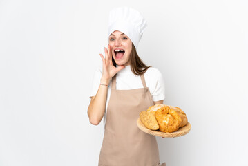 Young woman in chef uniform isolated on white background shouting with mouth wide open