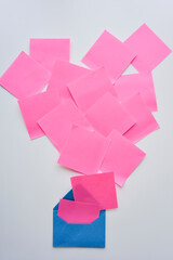 selective focus, pink paper stickers in chaos and blue envelope on the white background